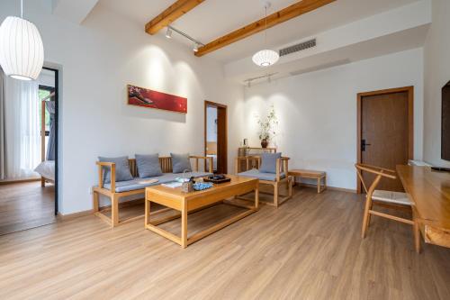 a living room with a couch and a table at 青城山喜遇安下私汤民宿 in Dujiangyan