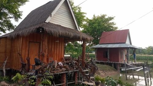 a small hut with a thatched roof and a small house at Meta Homestay in Phumĭ Puŏk Chăs