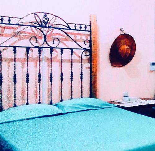 a bedroom with a bed with a iron head board at Hostal y Camping Villa Mercedes in Tizimín