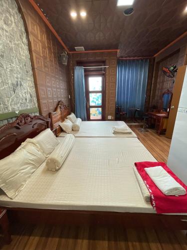 a large white bed in a room with blue curtains at Duy Anh Hotel Biên Hoà in Bien Hoa