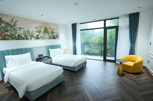 a hotel room with two beds and a window at Belliss Hotel And Spa Dai Lai in Phúc Yên