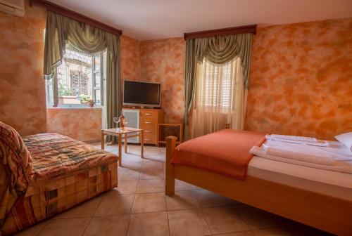 a hotel room with two beds and a television at Hotel Rendez Vous in Kotor