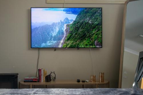 a flat screen tv hanging on a wall at Relaxing Guest Home Near Airport in Sydney