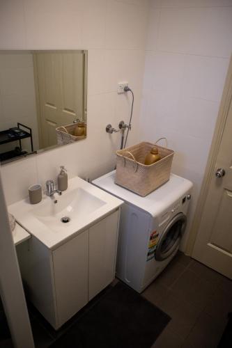 a bathroom with a washing machine and a sink at Relaxing Guest Home Near Airport in Sydney