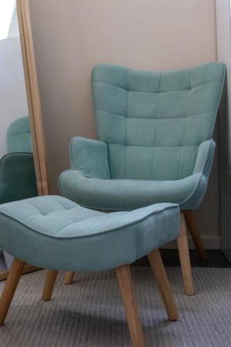 a blue chair sitting next to a mirror at Relaxing Guest Home Near Airport in Sydney