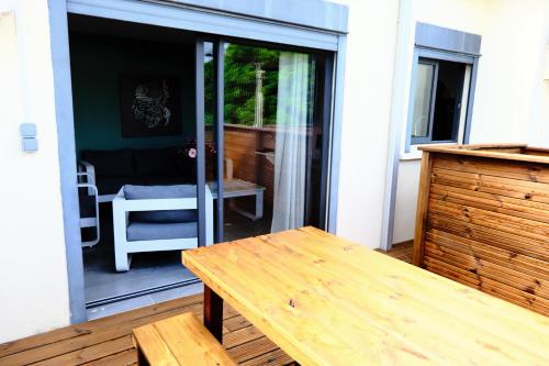 a patio with a wooden table and a sliding glass door at T3 - 100m2 - Résidence Georgette in Terre Sainte