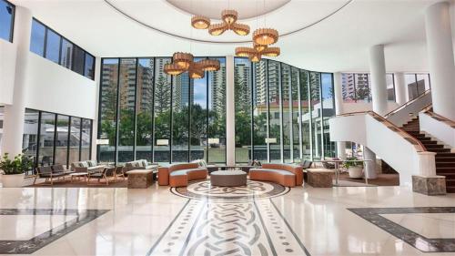 a lobby with couches and a staircase in a building at Legends Resort 9th Floor Ocean Views - CoastHM in Gold Coast