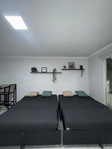 a room with two beds and a table and a window at Apartamento en Laureles Medellin in Medellín