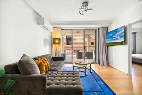 a living room with a couch and a table at Spacious 2-Bed Apartment Near Parramatta CBD in Sydney