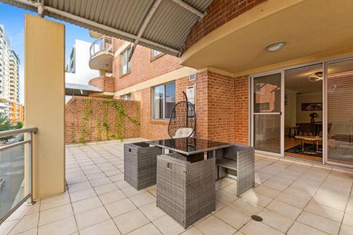 an outdoor kitchen with a table on a patio at Spacious 2-Bed Apartment Near Parramatta CBD in Sydney