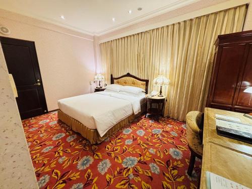 a hotel room with a bed and a red carpet at Royal Seasons Hotel Taipei ‧ Nanjing W. in Taipei