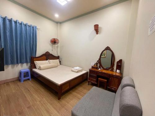a bedroom with a bed and a mirror and a couch at Duy Anh Hotel Biên Hoà in Bien Hoa