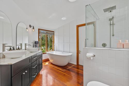 a bathroom with two sinks and a large tub at Riverview Retreat in Riverhead