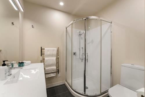 a bathroom with a shower and a toilet and a sink at The Moorings Apartment 6 - Close to the Lake! in Taupo
