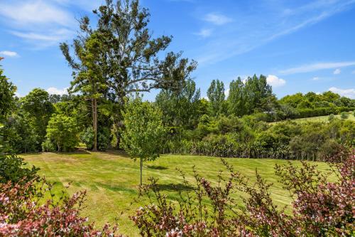 a large grassy field with trees in the background at Riverview Retreat in Riverhead