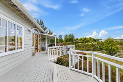 a white house with a porch and a balcony at Riverview Retreat in Riverhead