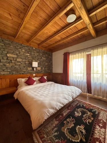Un dormitorio con una cama y una pared de piedra. en Resort Thasang Village, en Lete