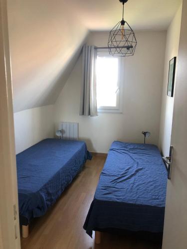 une chambre avec deux lits et une fenêtre dans l'établissement Le petit navire - accès direct plage, à Cabourg