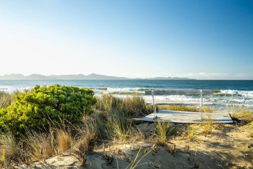a bench on the beach with the ocean in the background at Nine Mile House in Swansea