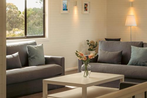 a living room with two couches and a table at Nine Mile House in Swansea