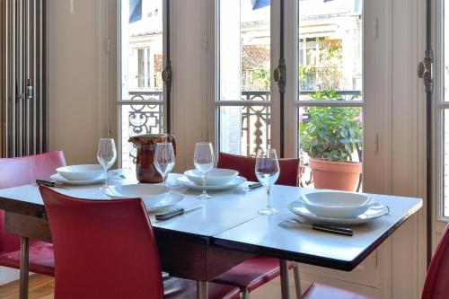 une table avec des assiettes et des verres à vin dessus dans l'établissement Appartement Poliveau - Welkeys, à Paris