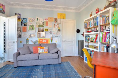 - un salon avec un canapé et des étagères dans l'établissement Appartement Poliveau - Welkeys, à Paris