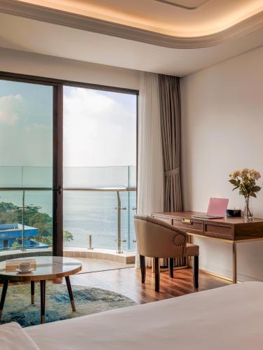 a hotel room with a desk and a table with a laptop at OYSTER BAY HOTEL VUNG TAU in Vung Tau