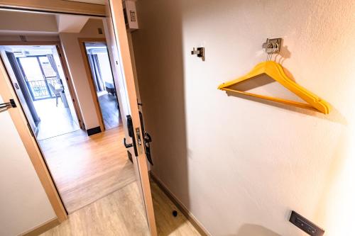 a door with a yellow hanger on a wall at Near Don Mueang Hotel in Don Muang Airport