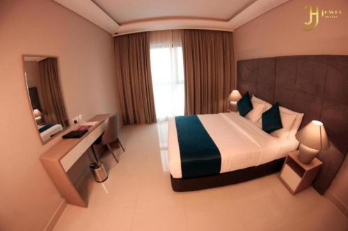 a hotel room with a bed and a desk at Dancenter Jewel Near World Trade Center in Manama