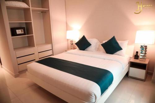 a bedroom with a large white bed with two lamps at Dancenter Jewel Near World Trade Center in Manama