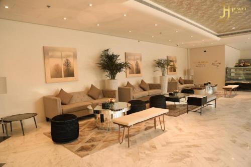 a living room with couches and tables and chairs at Dancenter Jewel Near World Trade Center in Manama