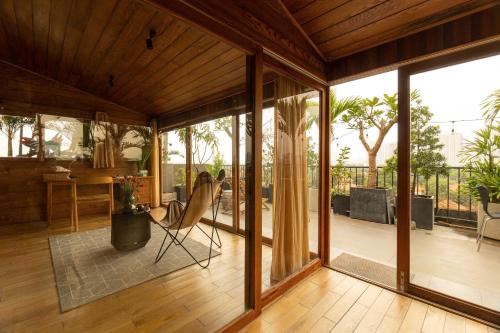 a living room with sliding glass doors and a chair at Nexus House Lang Bao Chi in Ho Chi Minh City