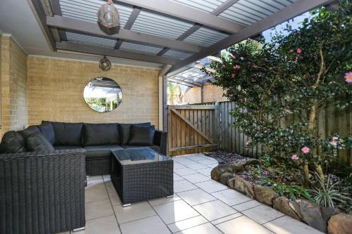 a patio with a couch and a fence at Vitamin Sea Pet Friendly in Hawks Nest