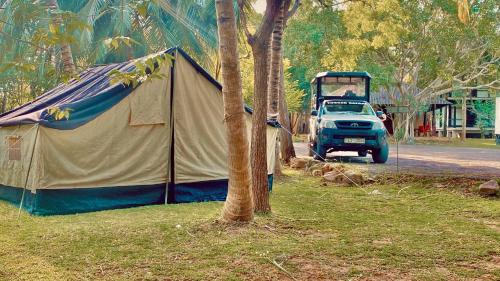 a tent and a car parked next to a street at Udawalawa Eco Lodge in Udawalawe
