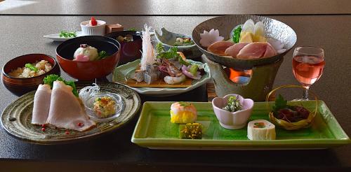 a table with plates of food on a table at Hotel Daisen Shirogane in Daisen
