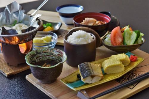a table topped with bowls of rice and sushi at Hotel Daisen Shirogane in Daisen