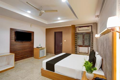 a bedroom with a bed and a flat screen tv at Super Collection O Awas Vikas Near Bus Stand Formerly Hotel Rivera in Rudrapur