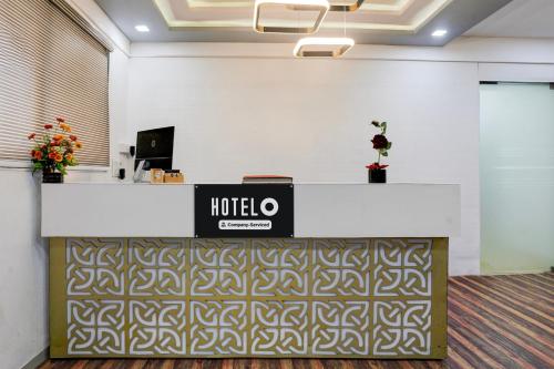 an office with a reception desk with a sign on it at Super Hotel O VIP Road formerly Hotel Lotus in Surat