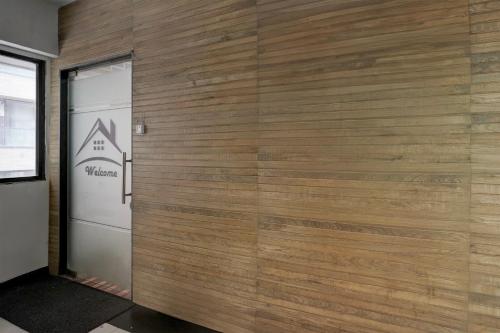 a wooden wall in a room with a door at Super Hotel O VIP Road formerly Hotel Lotus in Surat