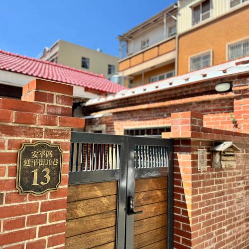 a brick building with a door with a sign on it at 老宅拾光Lao Shih Kuang-預訂後聯繫才會保留 in Tainan