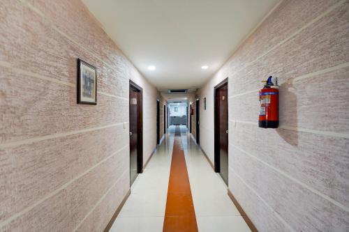 a hallway with a fire extinguisher on the wall at Super Collection O Awas Vikas Near Bus Stand Formerly Hotel Rivera in Rudrapur