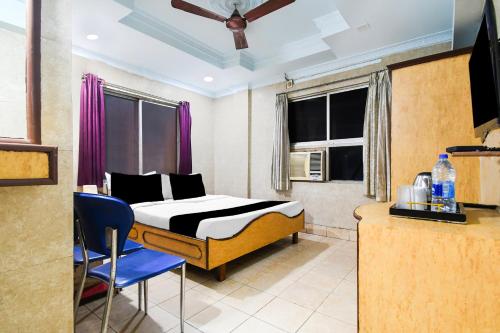 a bedroom with a bed and a blue chair at Super Collection O Bhubaneswar City Center in Bhubaneshwar
