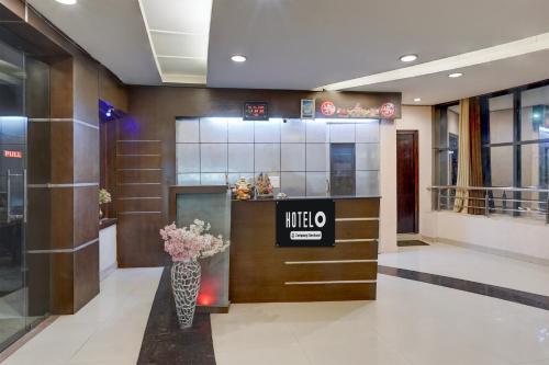 a lobby with a vase of flowers on a counter at Super Collection O Awas Vikas Near Bus Stand Formerly Hotel Rivera in Rudrapur