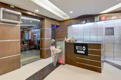 a lobby with a mico sign and a vase of flowers at Super Collection O Awas Vikas Near Bus Stand Formerly Hotel Rivera in Rudrapur