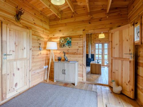 a living room with wooden walls and a room with a lamp at Halfmoon Wood - Ukc2194 in Caunton