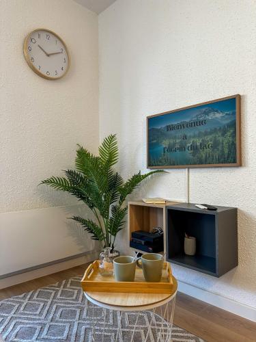 a living room with a coffee table and a clock at L'écrin du Lac St-Point in Malbuisson