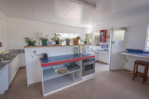 a kitchen with a sink and a stove in it at Cosy Cottage Thermal Holiday Park in Rotorua