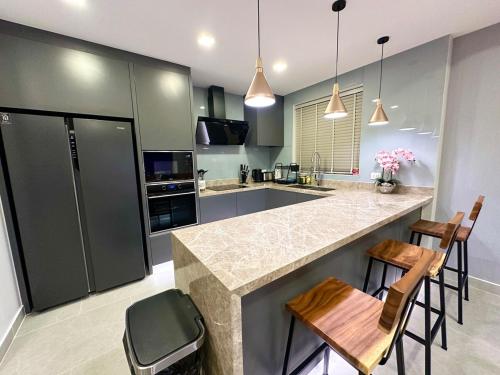 a kitchen with a counter and some chairs in it at Super Luxury 3 Bedroom Private Pool Villa with Jacuzzi, Near 711, 10 minutes to Walking Street and Pattaya Beach - MT8 in Pattaya