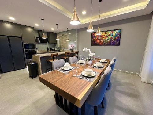 a dining room with a wooden table and blue chairs at Super Luxury 3 Bedroom Private Pool Villa with Jacuzzi, Near 711, 10 minutes to Walking Street and Pattaya Beach - MT8 in Pattaya
