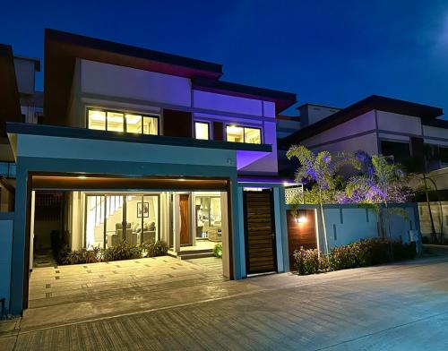 a house with a garage in front of it at Super Luxury 3 Bedroom Private Pool Villa with Jacuzzi, Near 711, 10 minutes to Walking Street and Pattaya Beach - MT8 in Pattaya